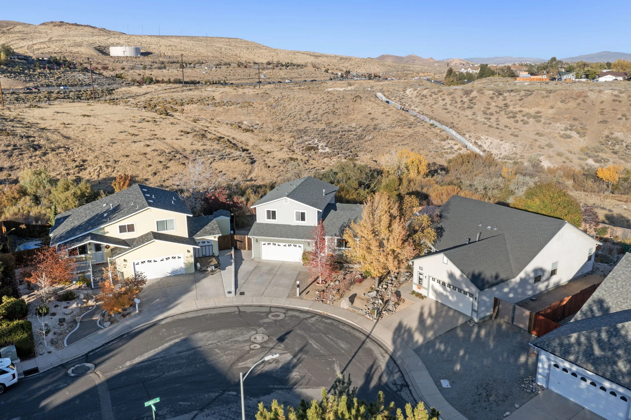 Aerial view showing the home's open-land backdrop and neighborhood setting